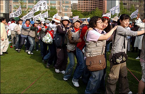 제116주년 세계 노동절 기념대회에 참석한 노동자들이 서로의 어깨를 잡고 길놀이를 하고 있다. 